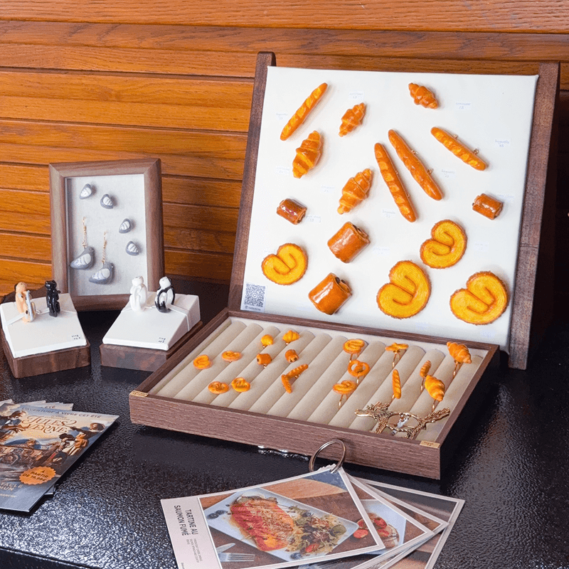 Miniature bread and pastry jewellery displayed in a wooden case at Aux Arts Etc..., Paris