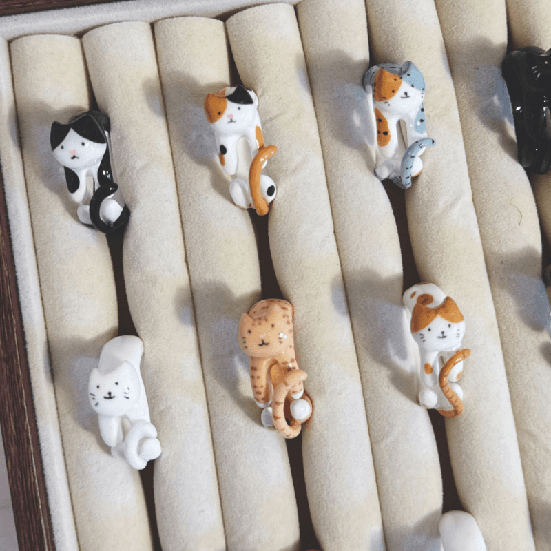 Miniature cat-shaped rings displayed in a jewellery tray