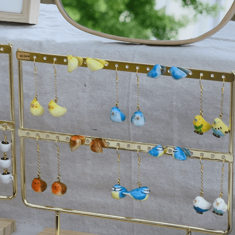 Miniature bird-shaped jewellery displayed on a tray